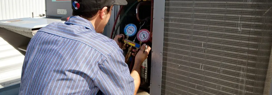 HVAC technician servicing a condenser unit in Franklin Town