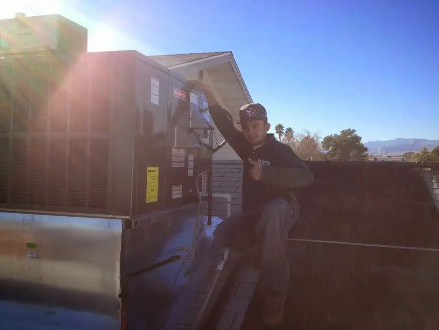HVAC technician performing HVAC Inspection on a rooftop unit in Franklin Town
